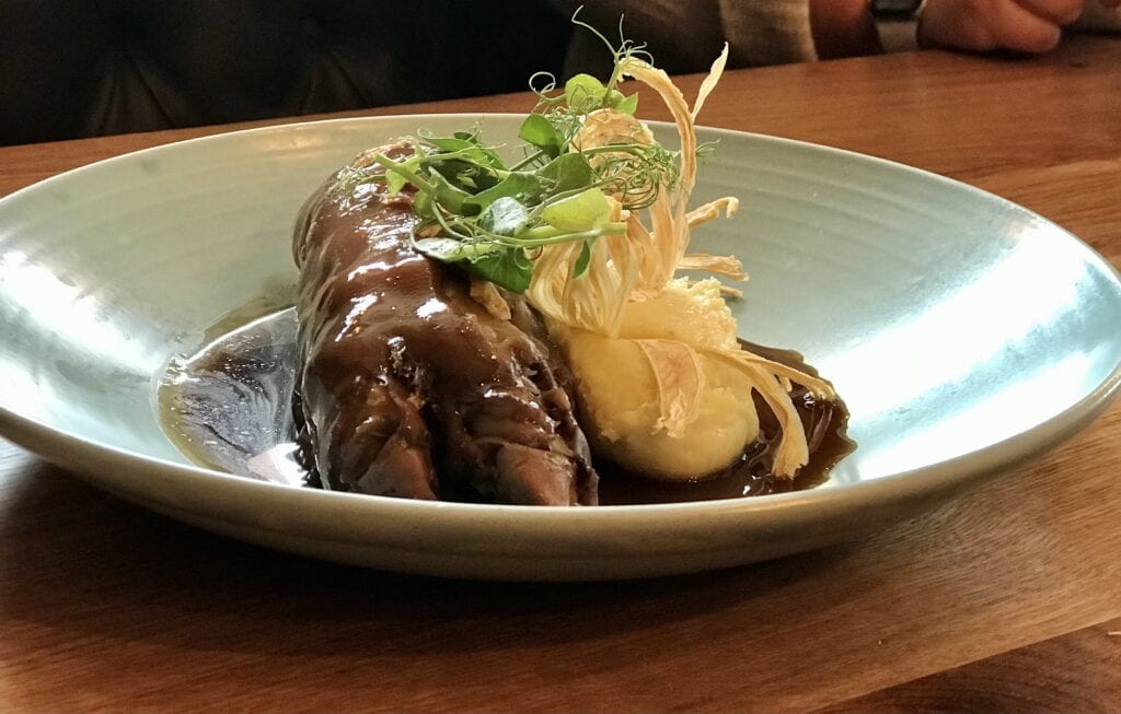 the yard braised pigs trotter stuffed with chicken mousse ham creamed potatoes onions